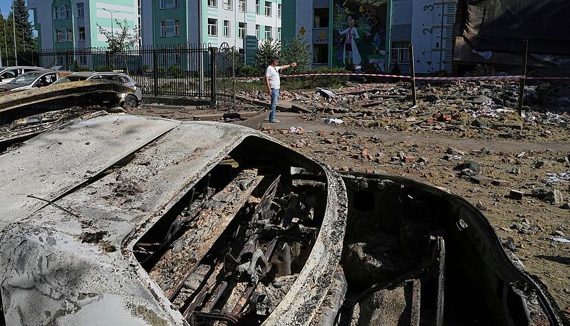 Nach einem russischen Drohnen- und Raketenangriff in Kiew liegen besch&auml;digte Autos in einem Hof zwischen anderen Tr&uuml;mmern.