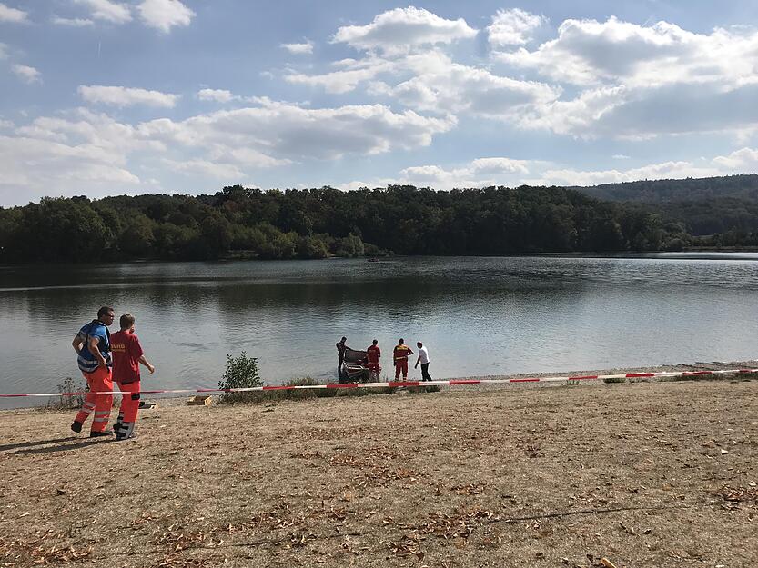 Die Einsatzkräfte besprechen die Bergung. Das Boot im Hintergrund markiert die Stelle, an der sich möglicherweise der Leichnam befindet. (Foto: Heike Kinkopf)