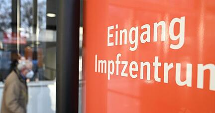 Ein Mann mit Gehhilfe geht im Kreisimpfzentrum in Ravensburg zu den Impfstraßen.