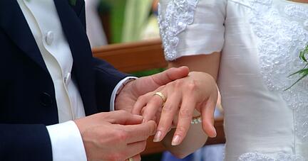 Br&auml;utigam steckt Ring an Finger der Braut