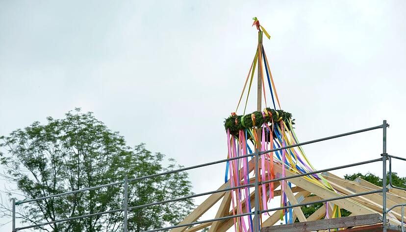 Richtkranz auf einem neu gebautem Haus. Richtfest auf einer L&uuml;ckenbebauung. An einem neu gebauten Wohnhaus im Speckg&uuml;rtel von Leipzig h&auml;ngt ein Richtkranz im rohbaufertigen Dachstuhl.