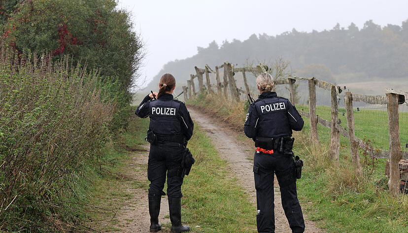 Polizisten sperren einen Weg zum Fundort einer Kinderleiche. Polizisten sperren einen Weg zum Fundort einer Kinderleiche.