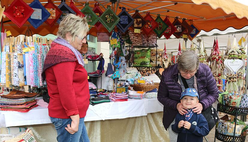 Passt perfekt: Damit Enkel Leo nicht am Hals friert, ersteht seine Oma Brygida Sobieski (rechts) am Stand von Beate H&auml;gele zwei Kinderhalst&uuml;cher.
Foto: Ute Pl&uuml;ckthun