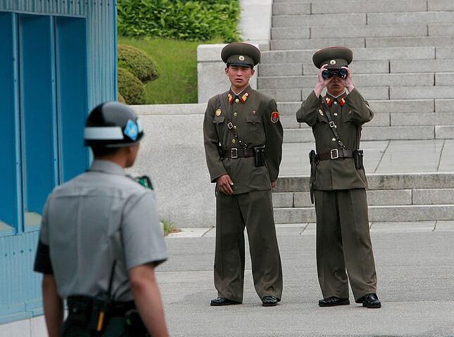 ARCHIV - Zwei nordkoreanische Soldaten (r) beobachten mit einem Fernglas einen südkoreanischen Soldaten (l) an der innerkoreanischen Grenze in der demilitarisierten Zone bei Panmunjom (Archivfoto vom 02.11.2007). Fast 30 Jahre lang trennte die Mauer Berlin in zwei Hälften. Zum 49. Jahrestag des Mauerbaus wirkt die Teilung schon weit entfernt. Aber für viele Staaten sind Mauertote und Grenzsoldaten noch immer brutale Realität. Auf der koreanischen Halbinsel stehen sich über eine Million Soldaten der nord- und südkoreanischen Armee am 38. Breitengrad gegenüber. Seit 1953 verläuft hier die sogenannte «demilitarisierte Zone» (DMZ) - eine 248 Kilometer lange militärische Pufferzone, die noch undurchdringlicher ist, als es die innerdeutsche Grenze jemals war. Mehrfach verstärkte Stacheldrahtzäune, Wachtürme, Landminen, Panzersperren - die Einheimischen nennen die DMZ auch «Niemandsland». Foto: JEON HEON-KYUN ACHTUNG zu dpa Mauern und Grenzsperren trennen noch immer Völker
vom 12.08.2010  +++(c) dpa - Bildfunk+++ |
