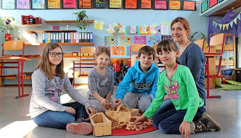 Buchstaben sortieren: (v. l.) Gabi (8), Susi (7), Samuel (9) und Pauline (8) unterscheiden mit Lehrerin Kerstin Freiseis Vokale und Konsonanten.Foto: Sara Furtw&auml;ngler