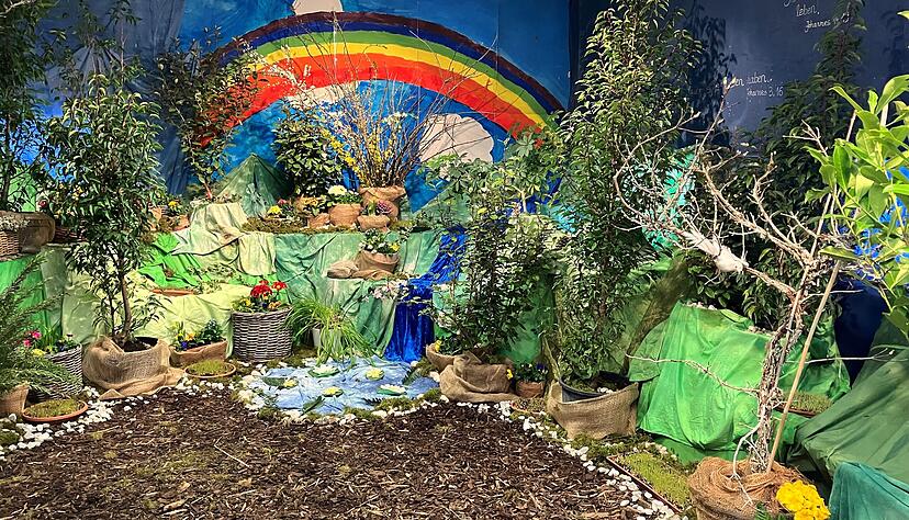 Pflanzen, ein Tisch, ein Regenbogen: Der sch&ouml;ne Garten symbolisiert die Auferstehung Jesu und den Sieg &uuml;ber Leiden und Tod.