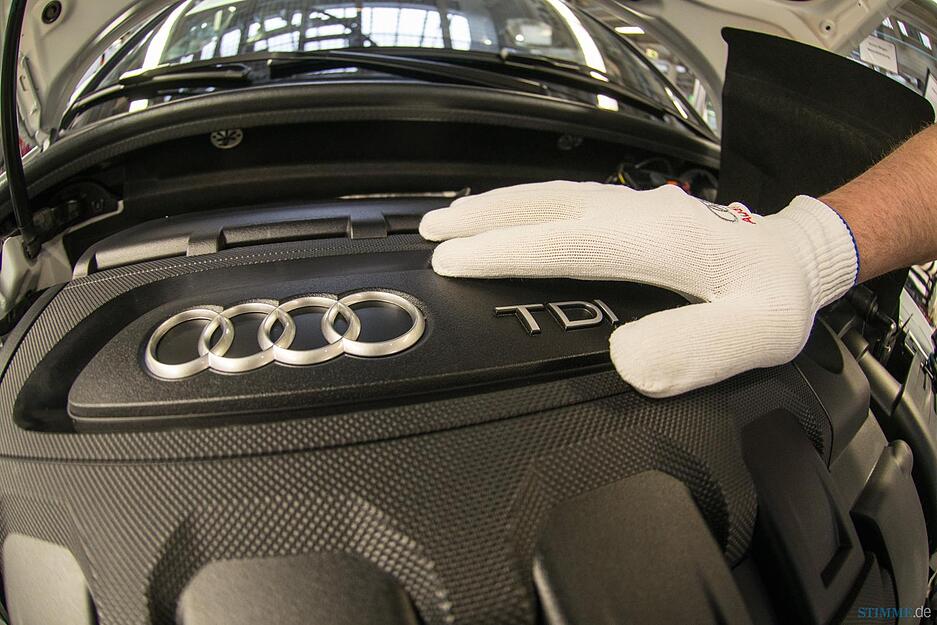 Ein Mann arbeitet in der Produktion von Audi an einem A3. Foto: Armin Weigel (dpa)