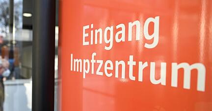 Ein Mann mit Gehhilfe geht zu den Impfstraßen.