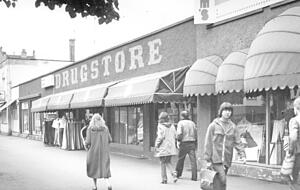Die Bahnhofstraße in den frühen 1960er Jahren wurde von Geschäften in barrackenähnlichen Gebäuden geprägt. im Hintergrund links ist das Alte Postamt zu erkennen. Erst in den 1980er Jahren veränderte sich das Bild der Bahnhofstraße.