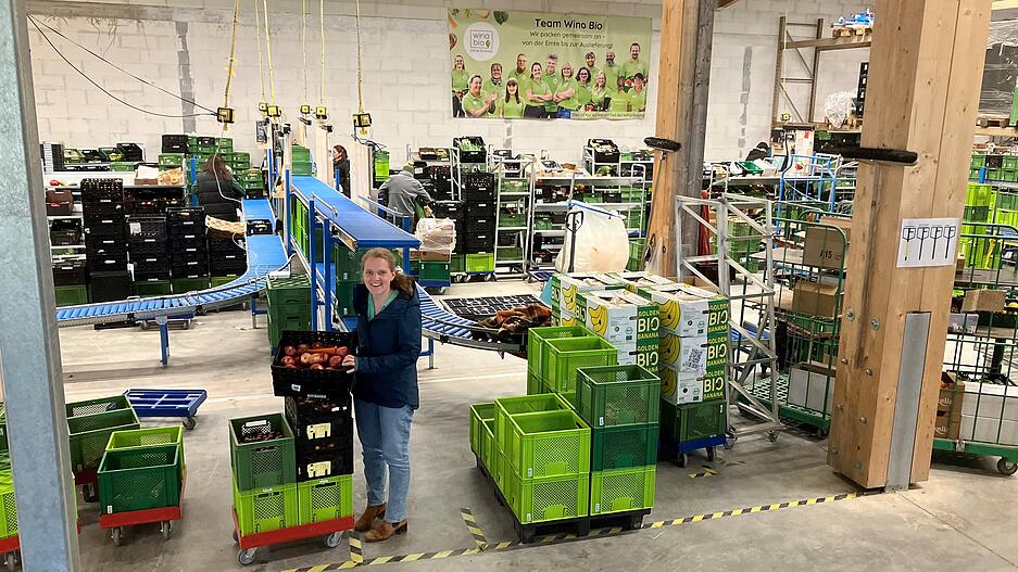 Marion Winkler (vorne) in der großen Halle, in der von Äpfeln bis zu Milch die Bestellungen der 1600 Kunden direkt vom Computer in die Kisten gepackt werden.