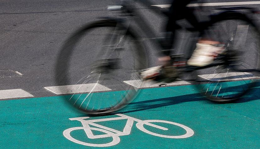 Eine Radfahrerin fährt in Leipzig über einen grün eingefärbten Radweg. Eine Radfahrerin fährt in Leipzig über einen grün eingefärbten Radweg.