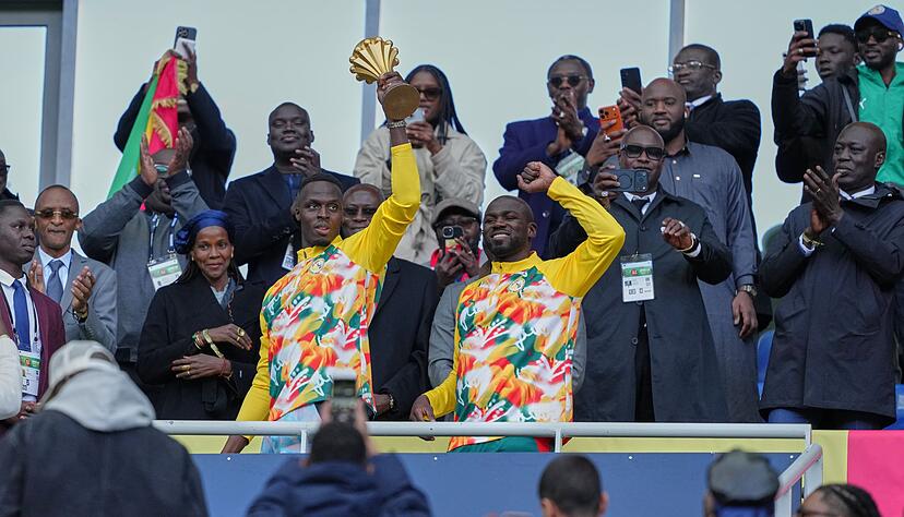 Senegalesische Spieler feiern mit der Afrika-Cup-Troph&auml;e vor dem Spiel.