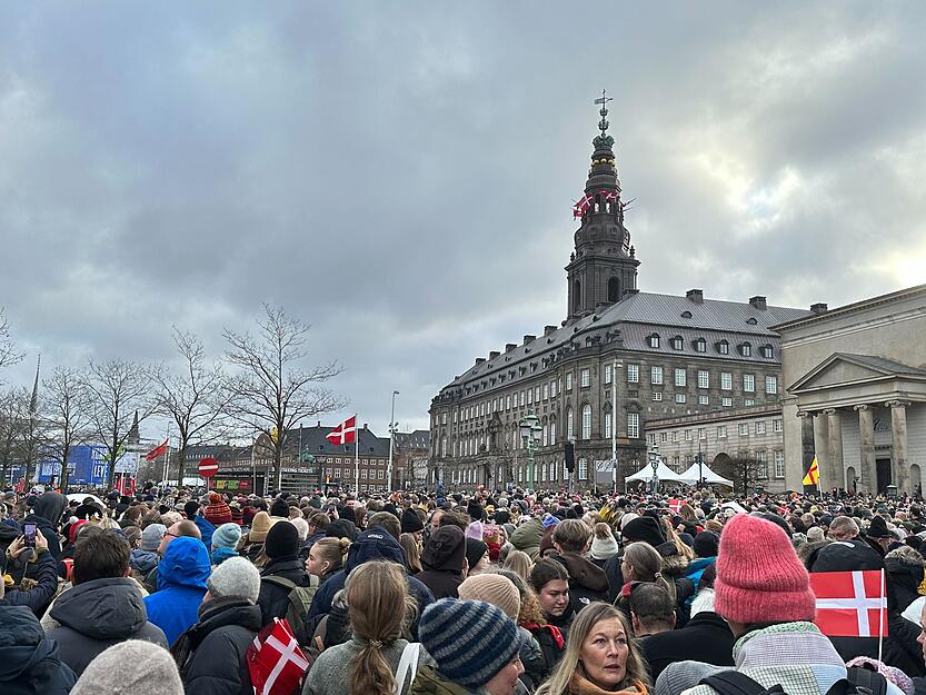 Menschen versammeln sich auf dem Platz von Schloss Christiansborg.