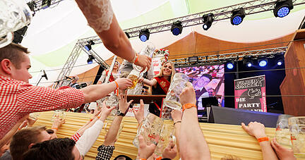 ARCHIV - 22.04.2023, Baden-Württemberg, Stuttgart: Nina Krippentz, Württembergische Bierprinzessin 2018-2023, verteilt das Bier vom Fassanstich an die Gäste im Festzelt. Nach dem «Frühlingsfest light» im vergangenen Jahr ist wieder ein Fest in normalem Rahmen geplant. An 23 Festtagen hoffen rund 250 Schaustellerbetriebe, Gastronomen und Marktkaufleute auf Besucher. Den Auftakt macht Wasenbürgermeister Thomas Fuhrmann mit dem traditionellen Fassanstich in «Grandls Hofbräuzelt».Ab 11.00 Uhr sind die Geschäfte in Betrieb. (zu dpa: «Der kleine große Rummelbruder: Frühlingsfest läuft sich warm») Foto: Julian Rettig/dpa +++ dpa-Bildfunk +++