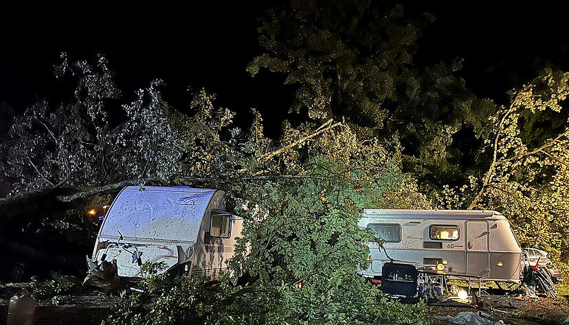 Bäume liegen nach einem Unwetter auf Campingwagen auf einem Campingplatz in Lindau.