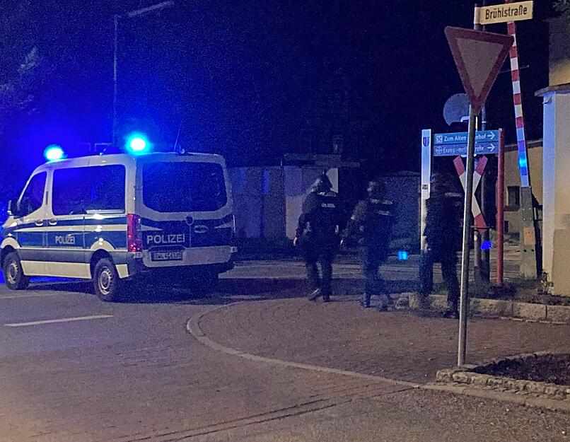 Schwer bewaffnete Polizisten suchen den Bereich rund um die Stelle ab, in der Freitagnacht Schüsse gefallen sind.