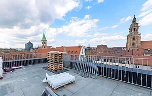 Blick vom Penthouse über die Dächer der Innenstadt mit Blick auf die Kilianskirche und das Deutschodensmünster.