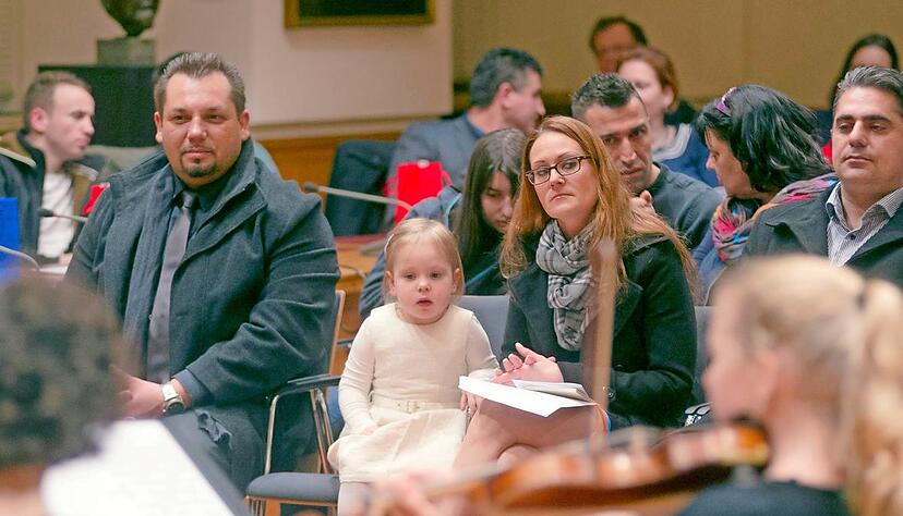 Während ein Musikschul-Ensemble munter aufspielt, freut sich Neubürger Petar Lucic (v.l.) mit Laura (2) und Ehefrau Sandra über die Einbürgerung.Foto: Dennis Mugler Während ein Musikschul-Ensemble munter aufspielt, freut sich Neubürger Petar Lucic (v.l.) mit Laura (2) und Ehefrau Sandra über die Einbürgerung.Foto: Dennis Mugler