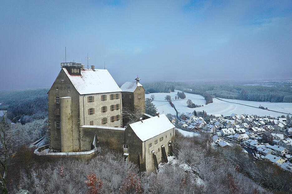 26.11.2023, Baden-Württemberg, Waldburg: Die Burg Waldburg ist mit Schnee bedeckt (Aufnahme mit Drohne). Über Nacht hat es in Oberschwaben und dem Allgäu zu schneien begonnen.