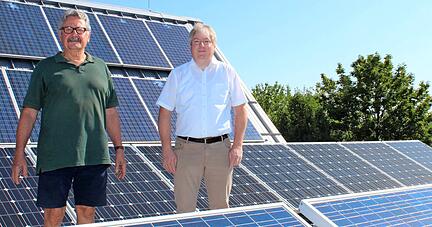 Heiner Blasenbrei-Wurtz (l.) und Jürgen Bothner auf dem Solardach der Schulturnhalle. Die 80 Eigentümer wollen die Anlage weiterbetreiben, doch 2021 ändert sich die Förderung nach dem EEG.
Foto: Birgit Riecker