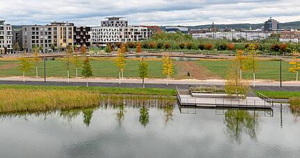 Blick vom Erdwall über den Karlssee und einige Baufelder des zweiten Bauabschnitts zum Floßhafen und die Gebäude der Stadtausstellung.
Foto: Mario Berger