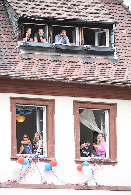 Zuschauer warten an den Fenstern eines Hauses auf den Besuch des britischen Prinzen William und seiner Frau Herzogin Kate in der Altstadt in Heidelberg.