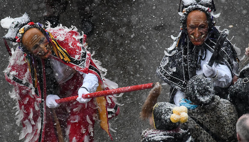 Zwei Federahannes, traditionelle Rottweiler Narrenfiguren, necken beim Narrensprung die Zuschauer. Foto: dpa